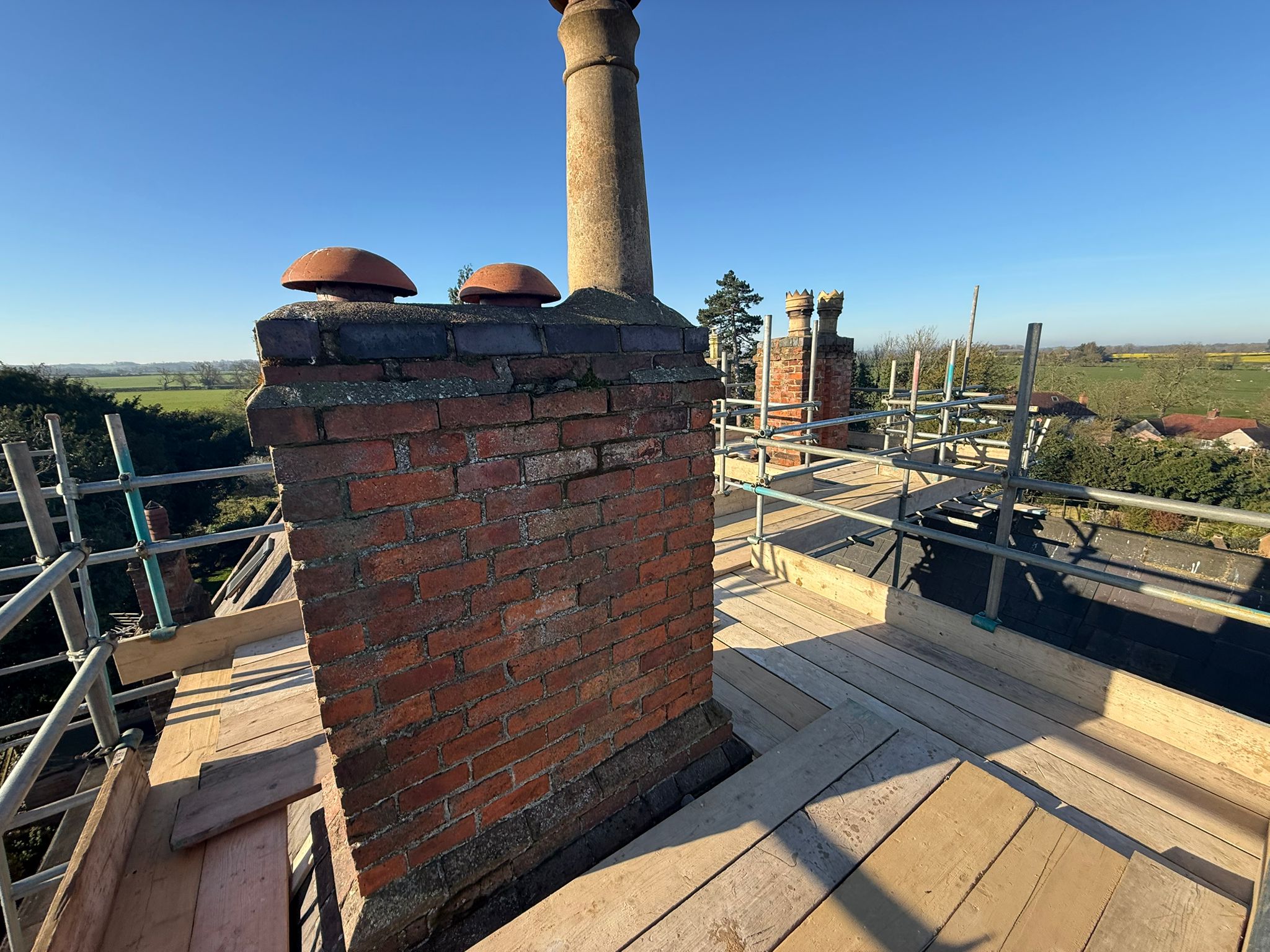 Scaffolded chimney stack during professional bee colony investigation and honeycomb removal works in Sibbertoft Northamptonshire