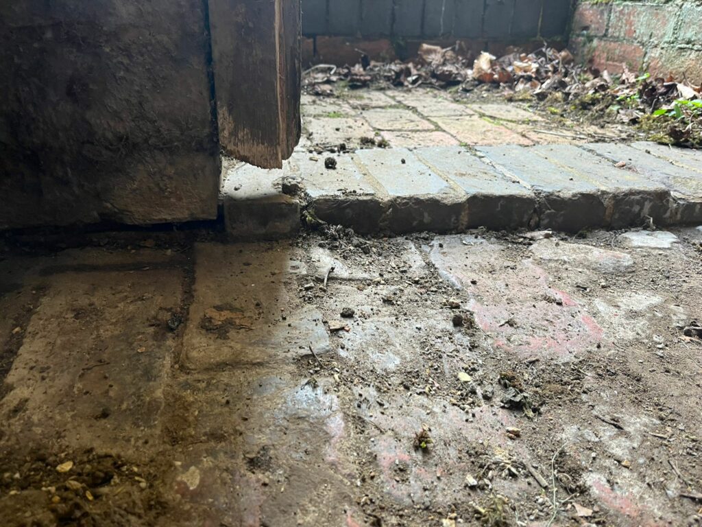 Damaged timber door frame creating a rat access point into a boiler room at a Northamptonshire church