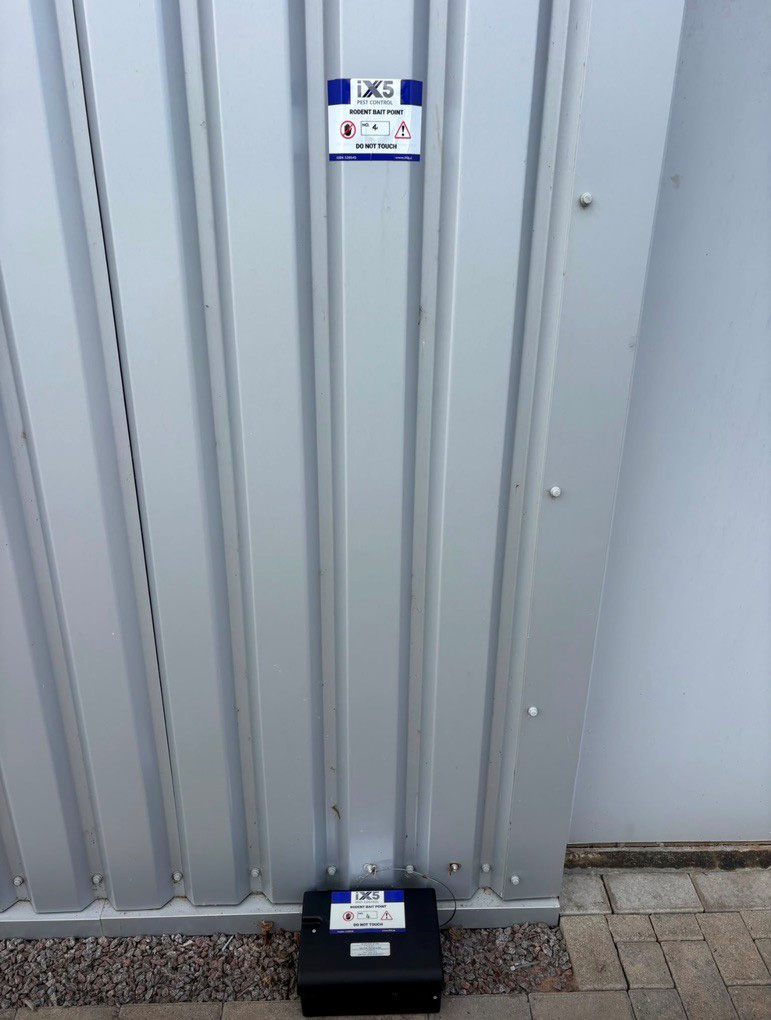 iX5 Pest Control rodent bait point with identification label installed at a commercial premises