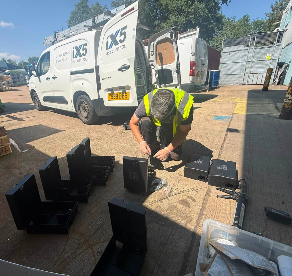 iX5 Pest Control technician setting up pest monitoring stations at a commercial site