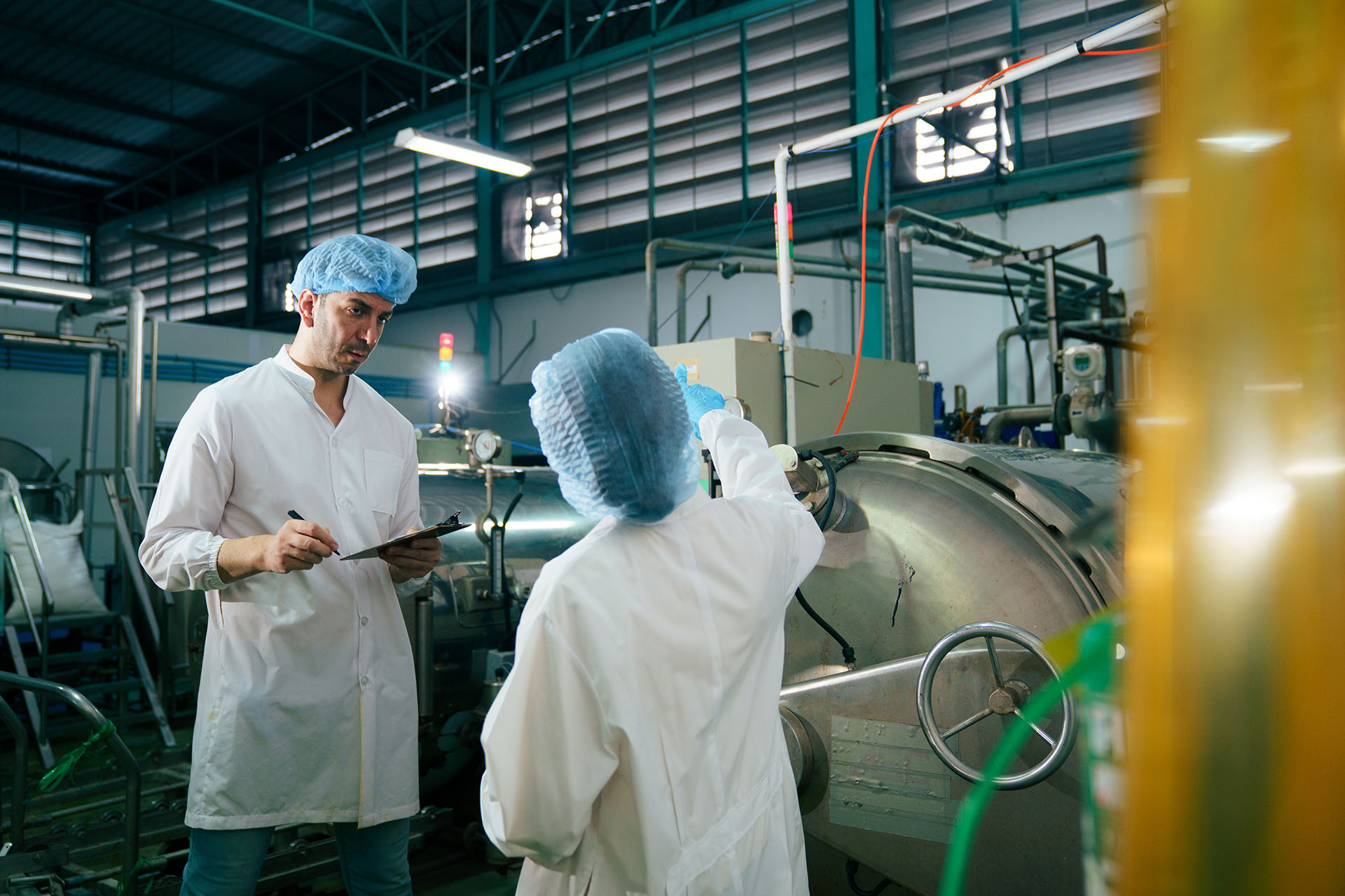 Food manufacturing site inspection with staff reviewing production equipment