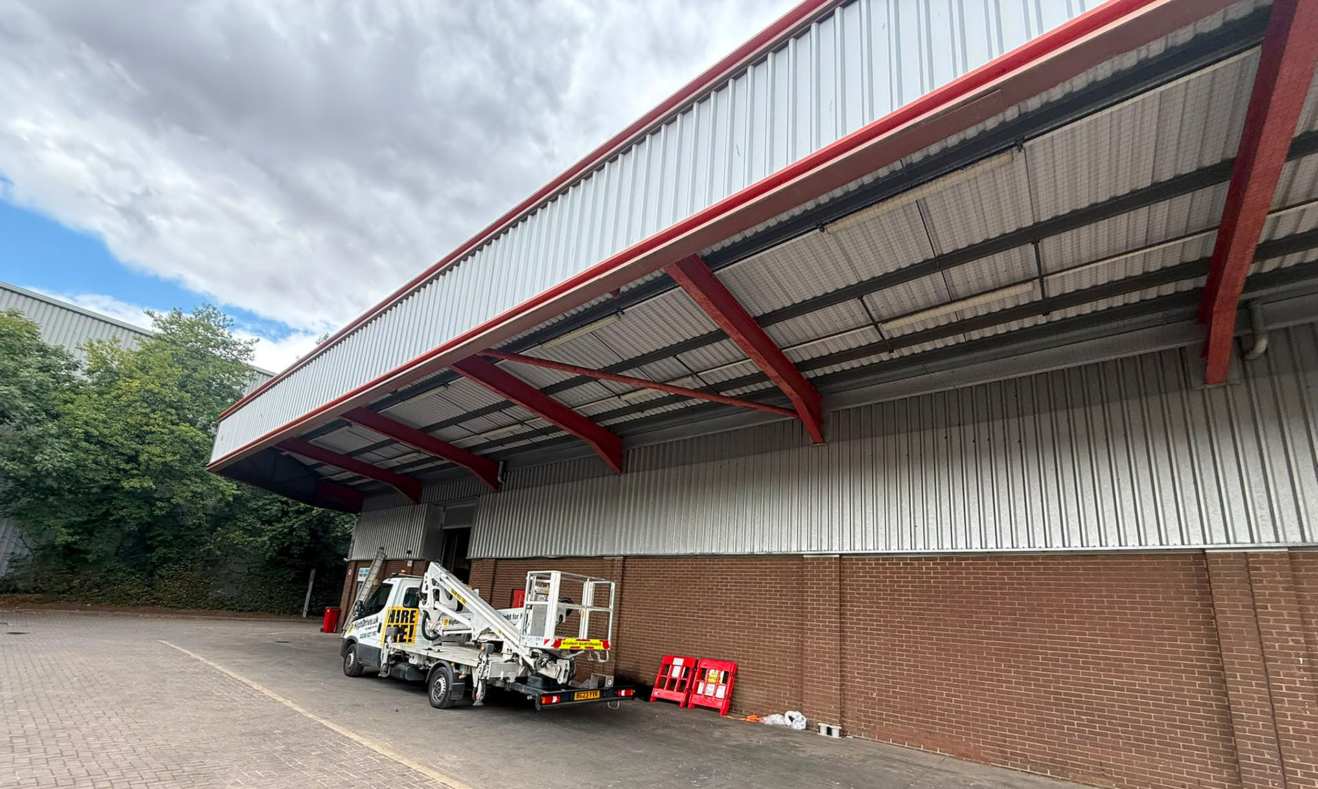 Commercial warehouse undergoing pest-proofing work around the roofline and loading area